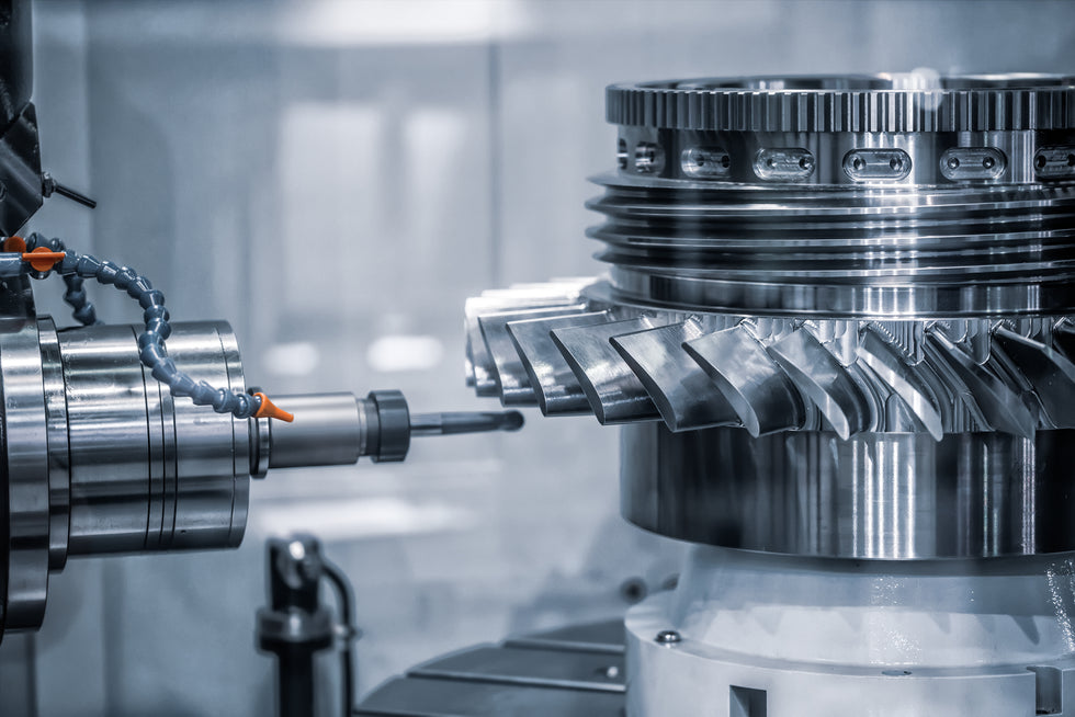 A close-up industrial scene showing a large machined turbine component with a milling tool approaching it in a clean factory setting.