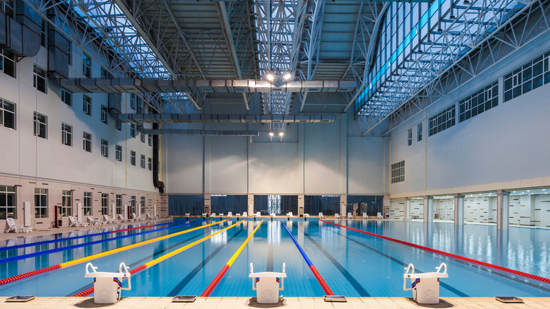 Large swimming pool in a high ceiling room. 
