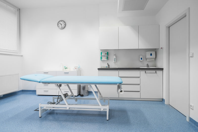 Medical clinic care room with bed and medical equipment