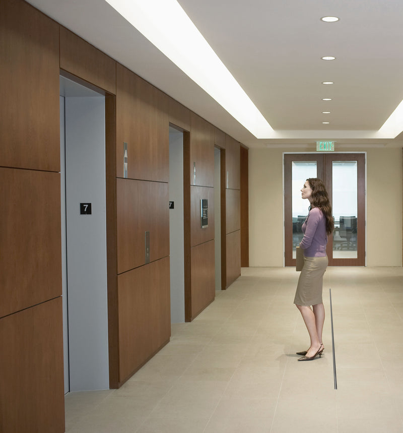 Woman standing in elevator lobby