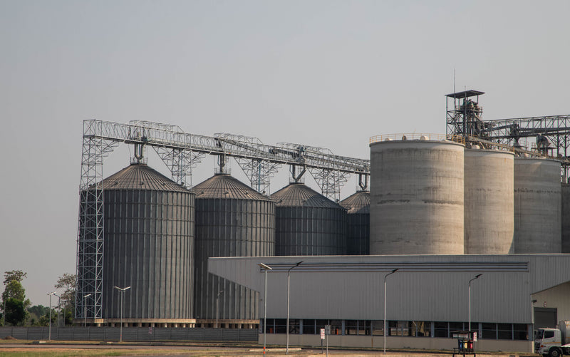 Multiple cement and corrugated metal grain storage bins. 