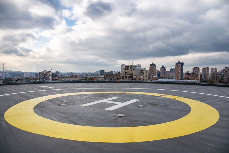 Rooftop helicopter landing pad with yellow circle and city skyline