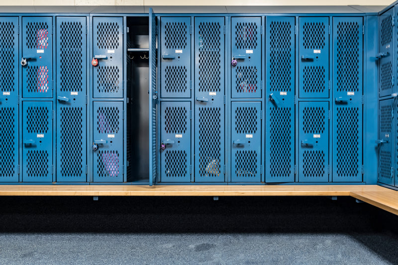 Lockers on the wall with open doors and a bench