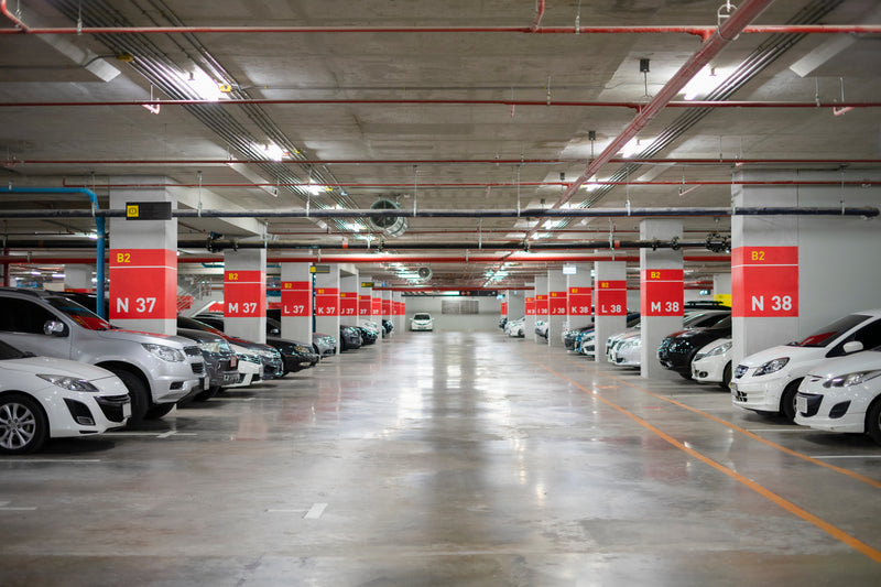 Large parking garage with many parked cars and lot signage