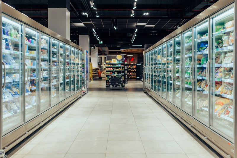 Supermarket aisle with upright freezer filled with food