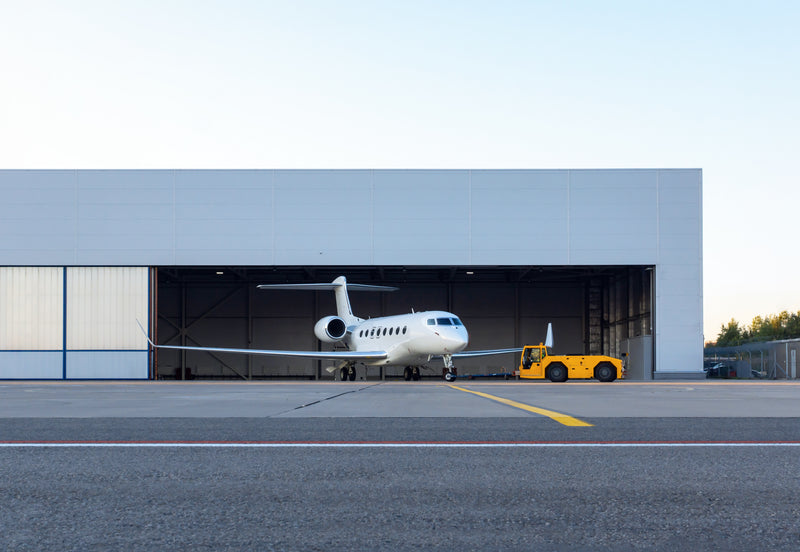 plane parked in hangar with yellow truck