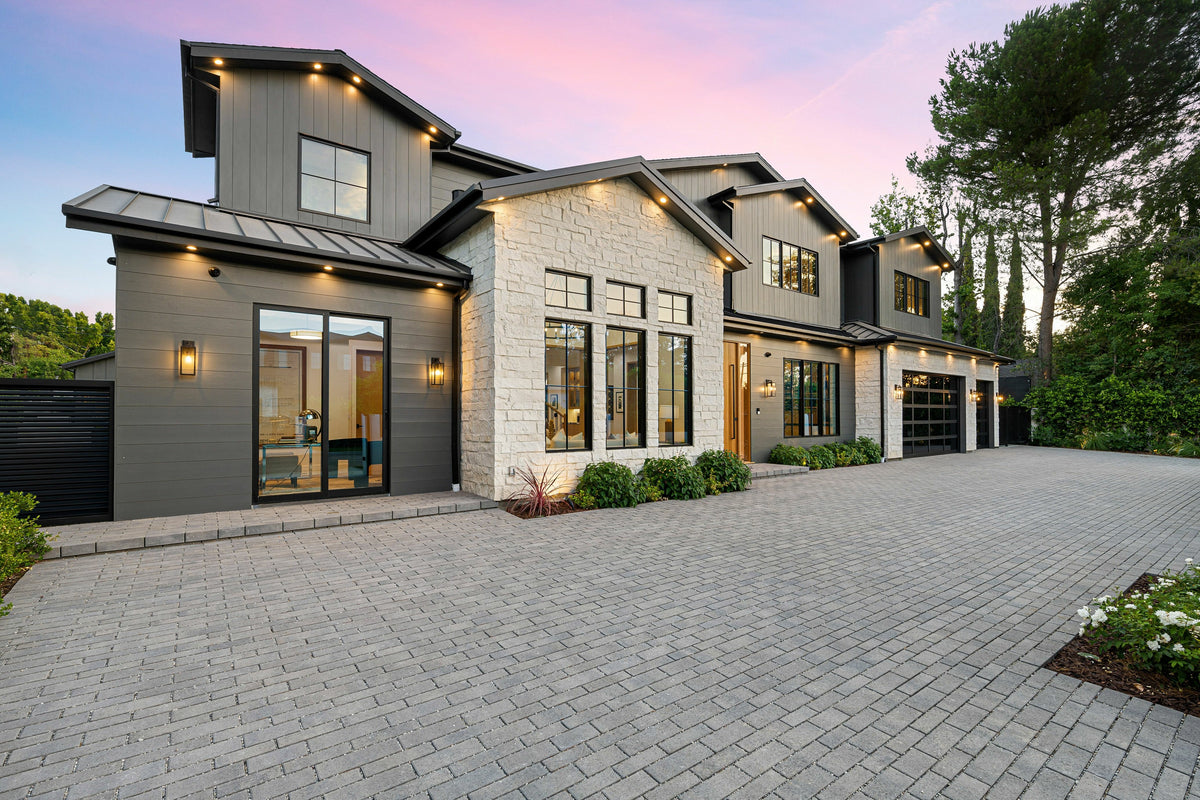 Modern house with a driveway and surrounding greenery